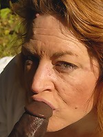 Horny red slut sucking on a big black pole