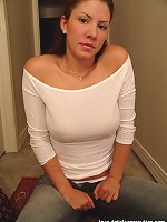 Tara posing in a braless white top