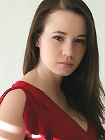 Steph poses in her red top in a studio