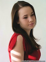 Steph poses in her red top in a studio