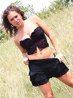 Jade outdoors in a field in a skirt on a windy day!