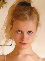 Lovely blond teenie undressing by the fireplace