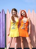 Cute lesbians in front of a fence