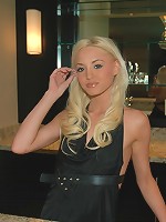 Kelly stands at the bar and strips off her dress.