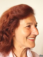 The redhead opens her robe and poses for the two guys painting her naked body