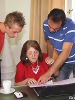 The nerdy mature in glasses and the suit is fucked at her work by eager guys