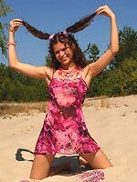 Cute brunette teen strips at the beach