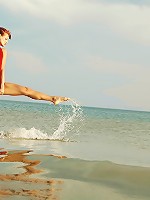 Natural redhead is getting naked on the beach