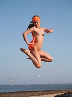 Small breasted gorgeous blonde with perky nipples jumping naked on the beach