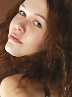 Curly brunette girl spreading legs naked on the bed