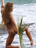 Fun and carefree, Masha frolics on beach, with sand and frothy water on her tight, untrimmed body.