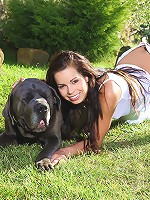Young beautiful teen plays with her dog in the yard