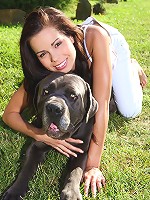 Young beautiful teen plays with her dog in the yard